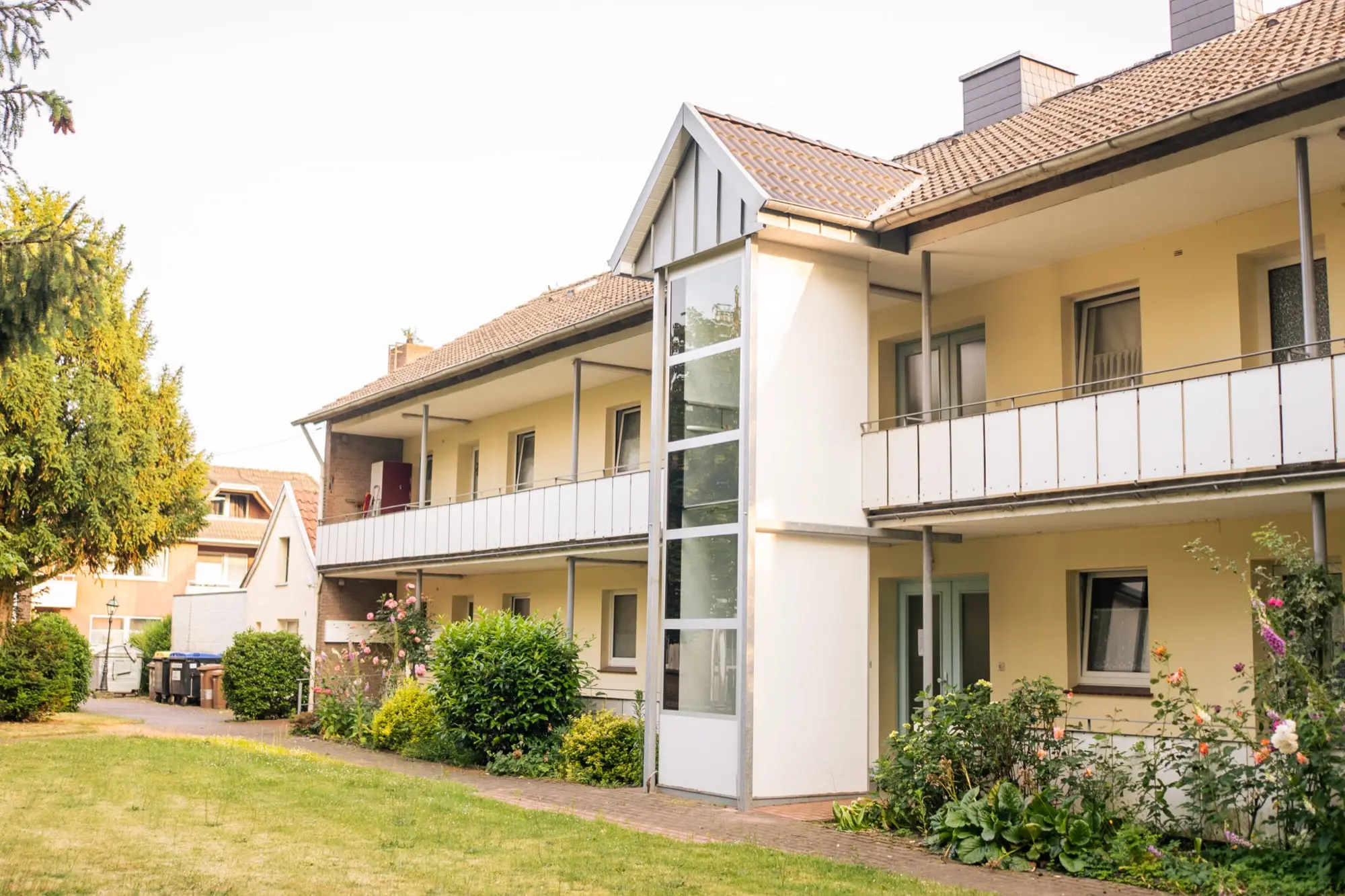 Helle Wohnanlage der St. Antoni-Stiftung mit Balkonen und Garten
